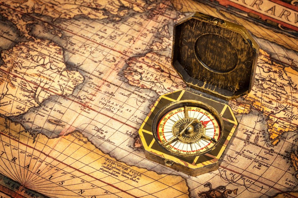 Vintage pirate compass on ancient map