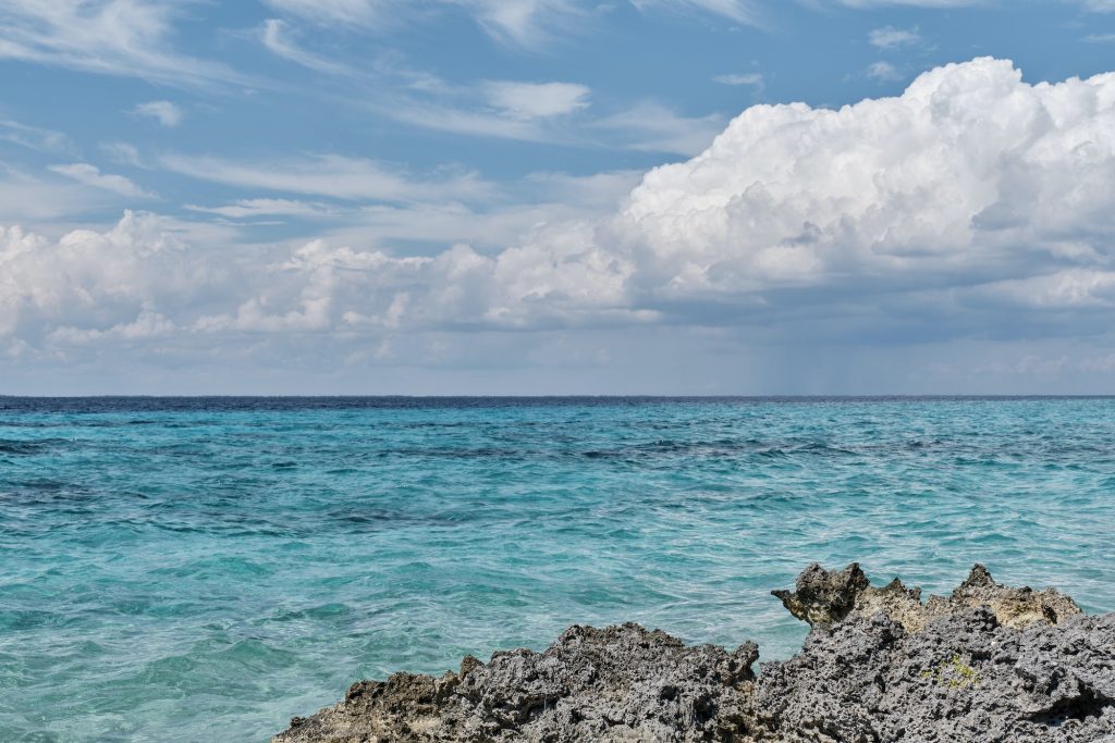 Beautiful sea and cloud landscape. Caribbean sea coast with turquoise water and stony beach