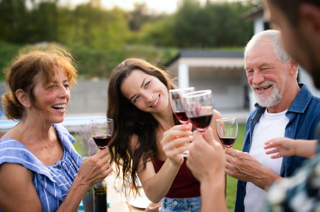 Portrait of people with wine outdoors on family garden barbecue