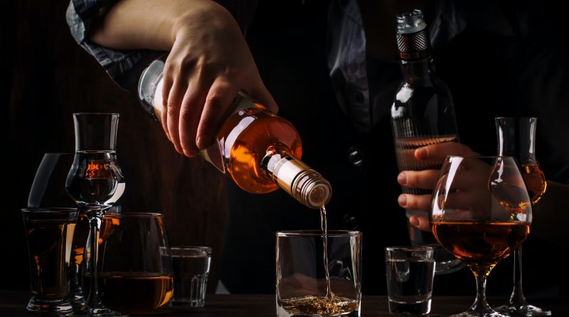 The bartender pours the dark golden rum