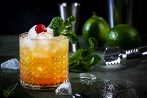 Mai Tai alcoholic cocktail with rum, liqueur, syrup, lime juice, mint and crushed ice