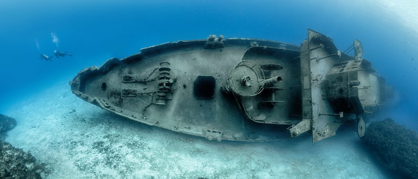 Divers examining the famous USS Kittiwake submarine wreck in the Grand Cayman Islands