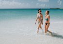 Two mid adult sisters strolling in blue sea, Anguilla, Saint Martin, Caribbean