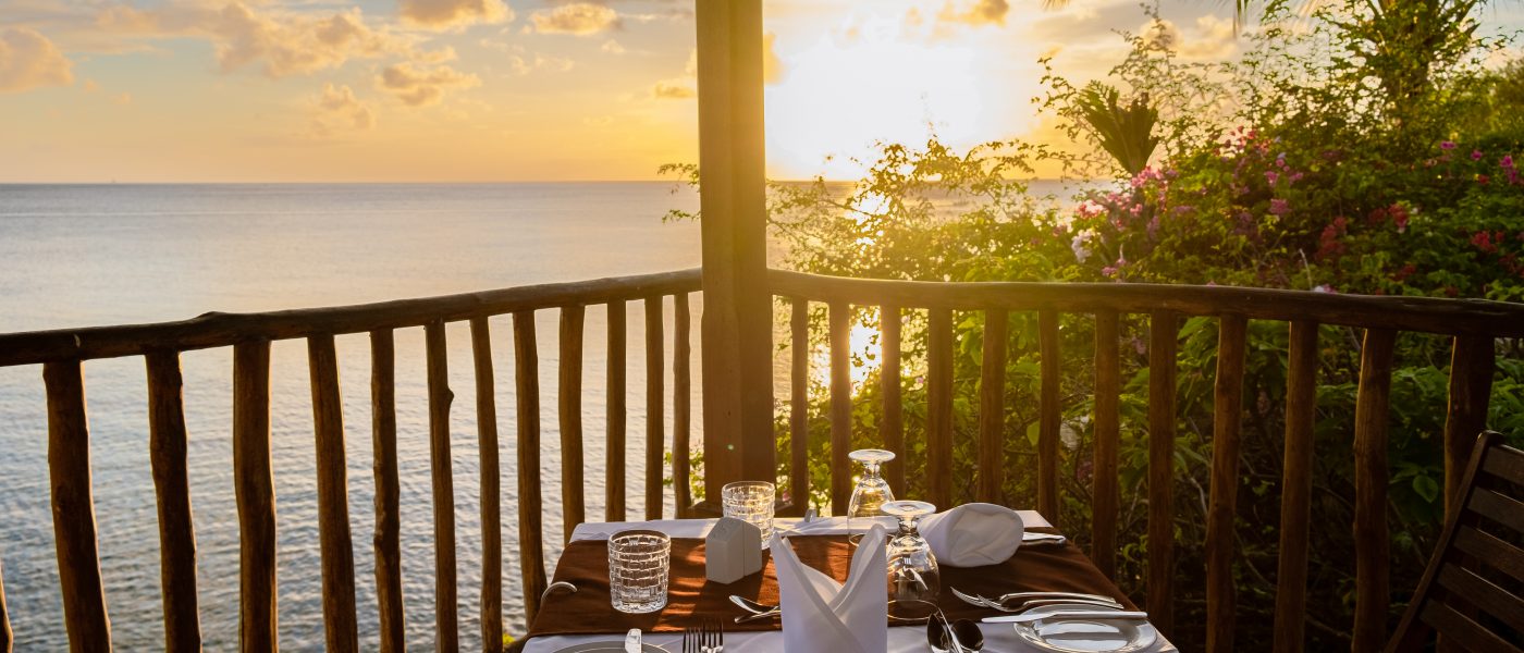 dinner table during sunset, romantic dinner by ocean watching the beautiful Caribbean ocean