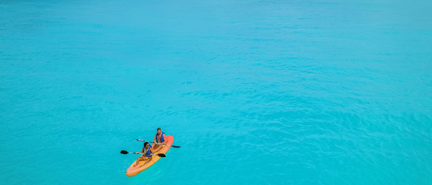 Couple Kayaking in the Ocean on Vacation Aruba Caribbean sea, man and woman mid age kayak in ocean