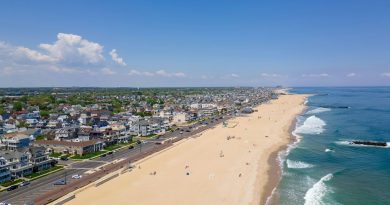 Drone shot of the Belmar Beach and coastal road and buildings on a sunny day in Belmar, New Jersey