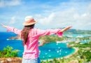 Young tourist woman with view of English Harbor from Shirley Heights, Antigua, paradise bay at