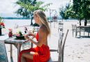 Satisfied young female eating exotic dish on beach