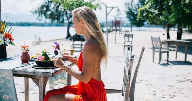 Satisfied young female eating exotic dish on beach