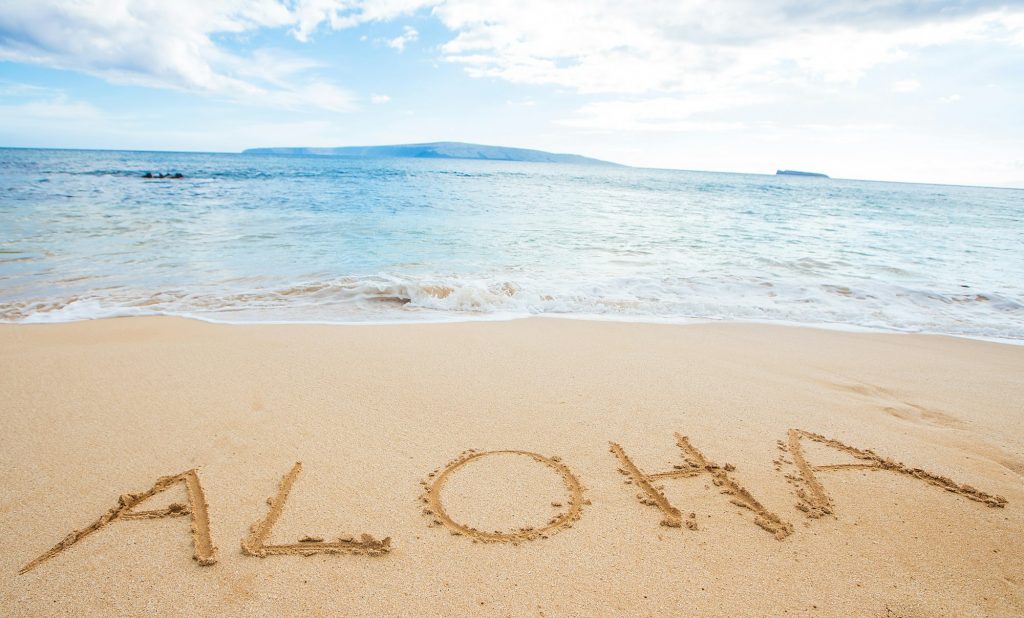 The word Aloha written in sand at the beach