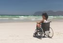 Woman disable sitting on wheelchair at beach