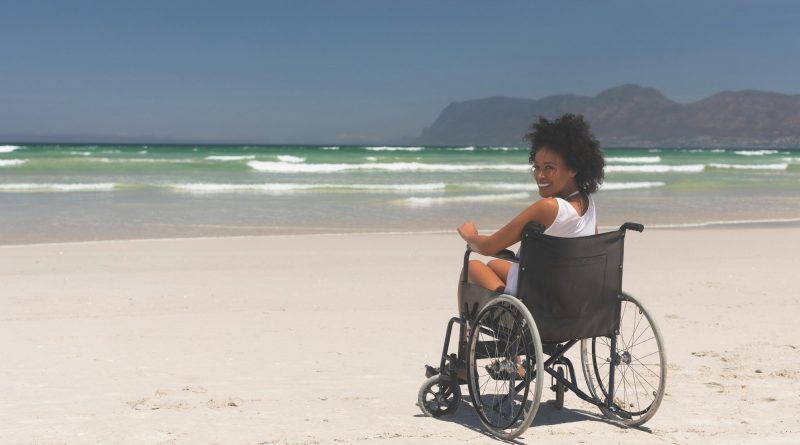 Woman disable sitting on wheelchair at beach