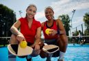 Happy female pickleball players on an outdoor court looking at camera.