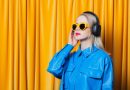 woman in blue shirt and yellow sunglasses with music headphones