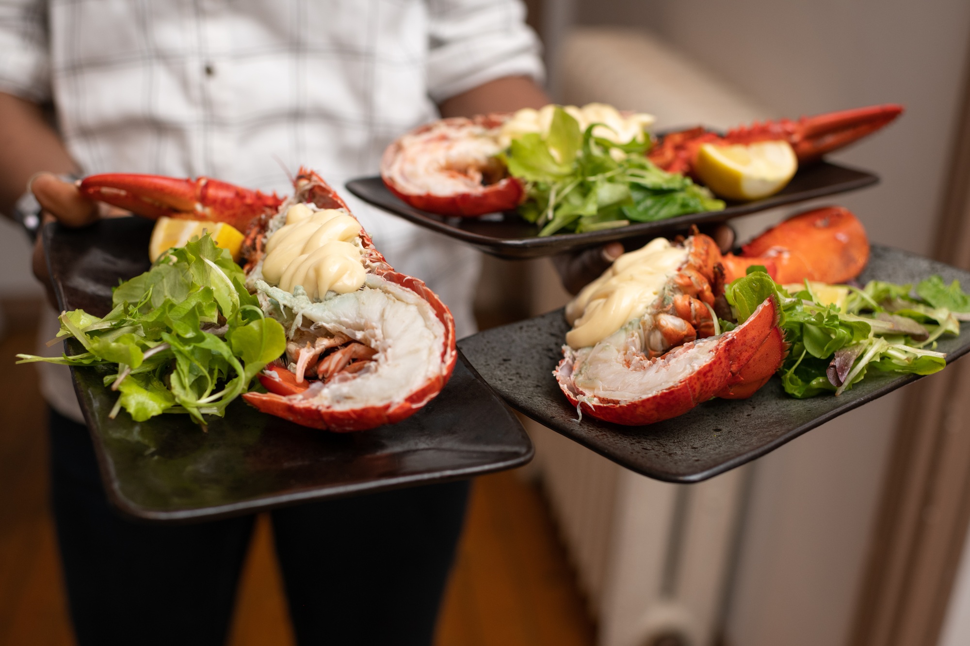 Waiter holding lobsters on a plate